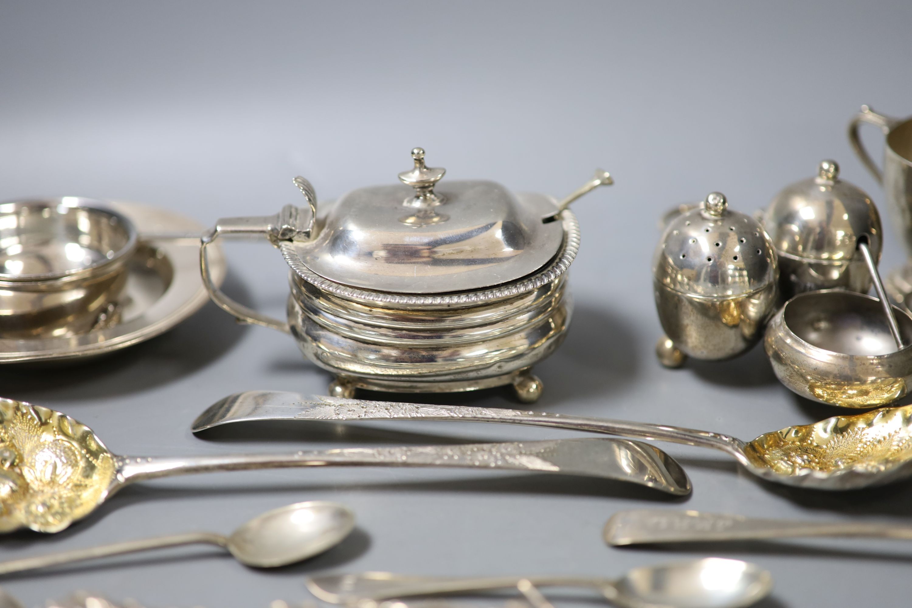 A group of small silver including a Georgian silver mustard, marks rubbed, a pair of Georgian silver berry spoons, two continental spoons, a small Victorian silver cruet stand, a tea strainer on stand, napkin ring, small